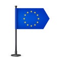 Realistic European table flag on a black steel pole. Souvenir from Europe. Desk flag made of paper or fabric and shiny