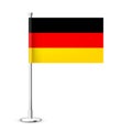 Realistic German table flag on a chrome steel pole. Souvenir from Germany. Desk flag made of paper or fabric and shiny