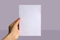 Realistic hand holding A5 paper mockup. Portrait A5 international paper size mockup