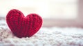 A close-up of a cozy, knitted red heart resting gently on a soft blanket, symbolizing love, warmth, and comfort in a serene Royalty Free Stock Photo