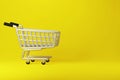 Realistic iron shopping cart on yellow background, 3d render