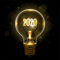 Realistic lamp with the inscription of 2020 year instead of the filament of incandescence, isolated on a dark background Royalty Free Stock Photo