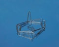 Realistic metal paper clip isolated on blue glass background.