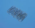 Realistic metal paper clip isolated on blue glass background.