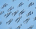Realistic metal paper clip isolated on blue glass background.