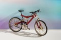 Realistic model of toy metal full-suspension mountain bike. Miniature bicycle on colored background