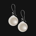 Realistic pearl earrings isolated on black background