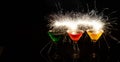 Realistic shot of three colorful cocktails with spark light on a black background Royalty Free Stock Photo