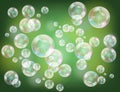Realistic soap bubbles with rainbow reflection set isolated on the green sparkling background Royalty Free Stock Photo