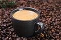 Realistic view of black espresso coffee in the dark cup in the roasted coffee beans. Cup with coffee crema and coffee beans.Close Royalty Free Stock Photo