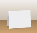 Realistic white blank folded paper card standing on wooden table Royalty Free Stock Photo