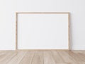 Frame mock up, Realistic wooden Blank frame, size A3 A4 on White Wall and standing on wooden floor Royalty Free Stock Photo