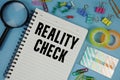 Reality Check text with magnifying glass on blue background Royalty Free Stock Photo
