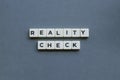 ' Reality Check ' word made of square letter word on grey background