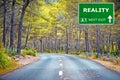 REALITY road sign against clear blue sky