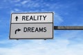 Reality versus dreams. Road sign with words reality and dreams. White two street signs with arrow on metal pole. Directional road Royalty Free Stock Photo