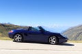 Blue roadster Porsche Boxster 986 and panorama with mountains at Furka Pass road