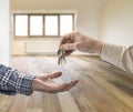 Realtor giving house key to buyer in loft room Royalty Free Stock Photo