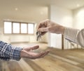 Realtor giving house key to buyer in loft room Royalty Free Stock Photo