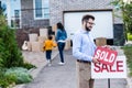 realtor hanging sold sign in front of people moving into Royalty Free Stock Photo