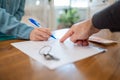 A realtor points to the contract for signing. Hands close-up. There are keys on the table. Rental and purchase of real estate Royalty Free Stock Photo