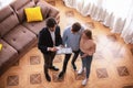 Realtor showing house plan to couple of young clients indoors, above view Royalty Free Stock Photo