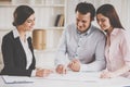 Realtor Shows Blueprints of New House to Couple.