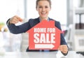 Realtor woman pointing on home for sale sign
