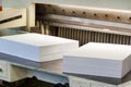 Reams of cut paper pages on a cutter machine