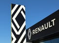 Renault totem signage with the brand name on background, hanging on the facade of the official car dealership.