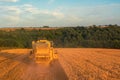 Rear aerial shot of a Combine Harvester harvesting a wheat field at Sunset in the UK Royalty Free Stock Photo