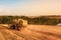 Rear aerial shot of a Combine Harvester harvesting a wheat field at Sunset in the UK Royalty Free Stock Photo