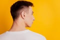 Rear back portrait of brutal masculine handsome guy look empty space on yellow background