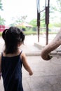 Rear back view of Asian girl feeding fruit food to the animal. The large elephant trunk was beside the little kid.