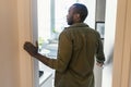 Rear back view of black guy walking in his apartment, entering new home, standing in doorway of modern flat Royalty Free Stock Photo