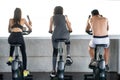 rear back view of Group of fitness people exercise with bikes together in gym . Cycling . workout . sport . training Royalty Free Stock Photo