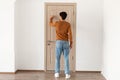 Rear back view of man knocking on the wooden door Royalty Free Stock Photo