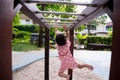 Rear back view. Preschool kid girl is hanging out on bar at playground. Healthy children exercise by having fun. Empty space. Royalty Free Stock Photo