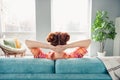 Rear behind portrait of calm carefree female person sit comfy sofa hands behind head look window sunlight spacious house Royalty Free Stock Photo