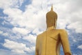 Rear of big golden Buddha statue against white cloud blue sky Royalty Free Stock Photo