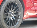 Rear closeup of red mustang with dark metallic wheel Royalty Free Stock Photo