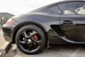 Rear detail of a black Porsche sports car on a parking