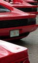 Rear ends of red exotic sports cars in a row