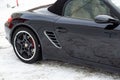 Rear fender view of the 2006 sports porsche boxster s coupe roadster prepared for sale with a polished shiny black body on snow