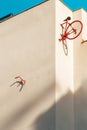 The rear half of a vintage bicycle and a red handlebar pinned to the wall of a minimalist building block with a turquoise blue sky Royalty Free Stock Photo