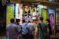 Rear of Indian people and tourists standing near the kulfi ice cream street shop in Mumbai at night