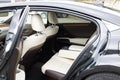 Rear leather passenger seats in modern lux car. White leather car passenger seat. Control unit with electric seat