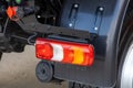 Rear lights of a new truck, close-up. Fragment of the back of the truck. Red brake lights and orange turn signals. Road Royalty Free Stock Photo