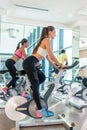 Fit women burning calories during indoor cycling class in a mode Royalty Free Stock Photo