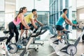 Fit women burning calories during indoor cycling class in the fitness club Royalty Free Stock Photo